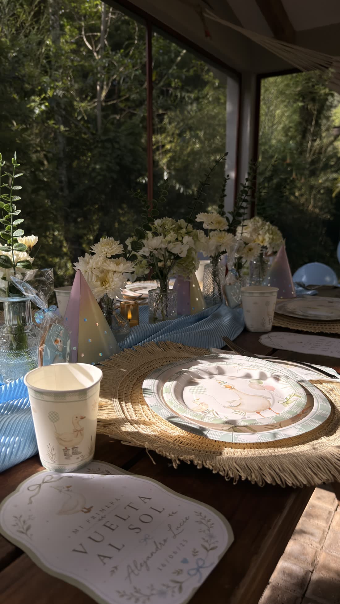 Mesa de celebración al aire libre diseñada por ETERIA con globos azul cielo y detalles florales.