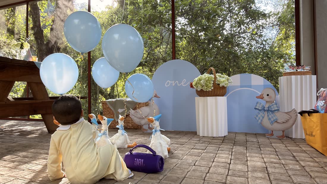 Ángulo lateral de montaje ETERIA al aire libre con globos azules y base floral.