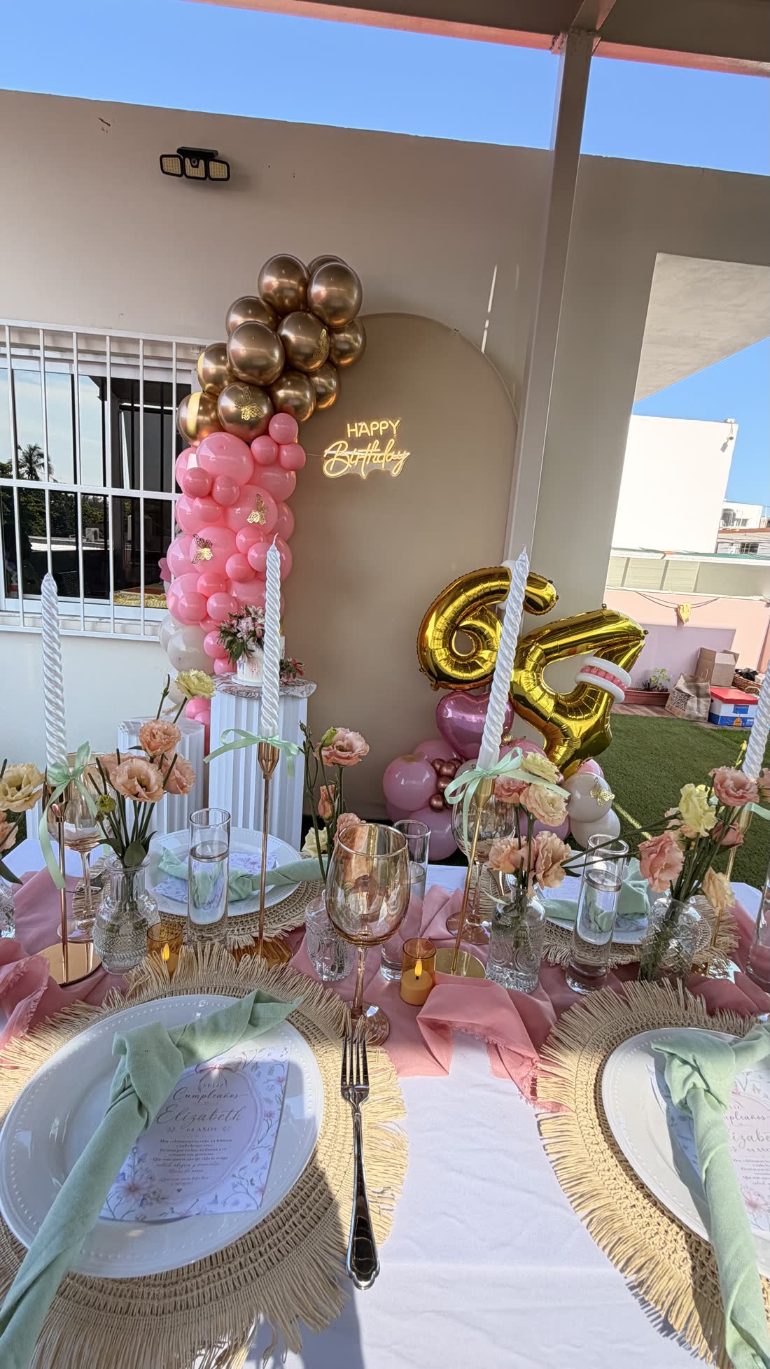 Vista de evento ETERIA en tonos rosa con globos dorados y mesa decorada.